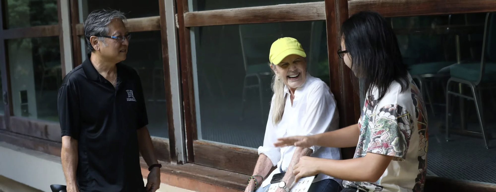Nancie Caraway laughing with two collaborators on a lānai