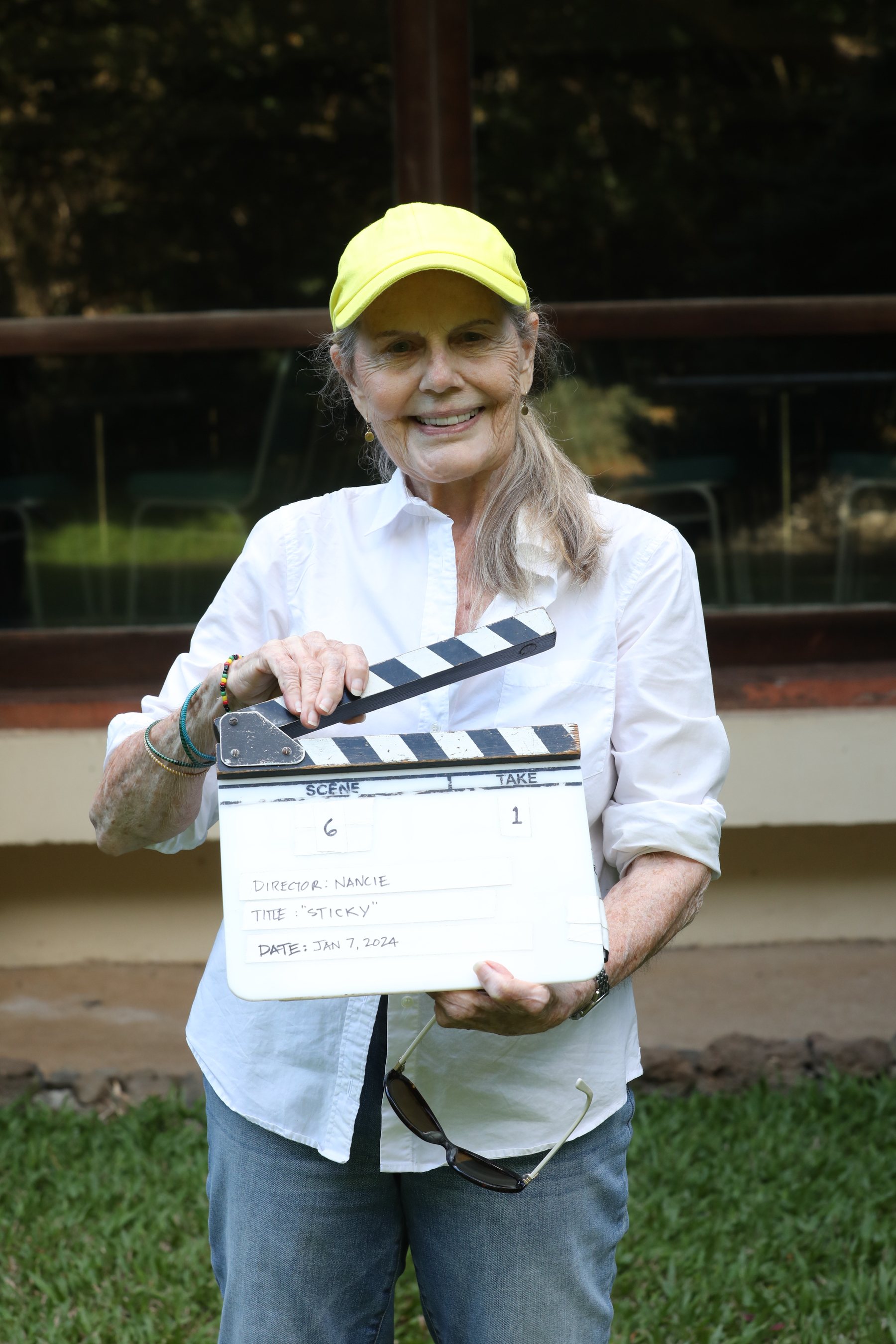 Nancie Caraway holding a clapperboard on set