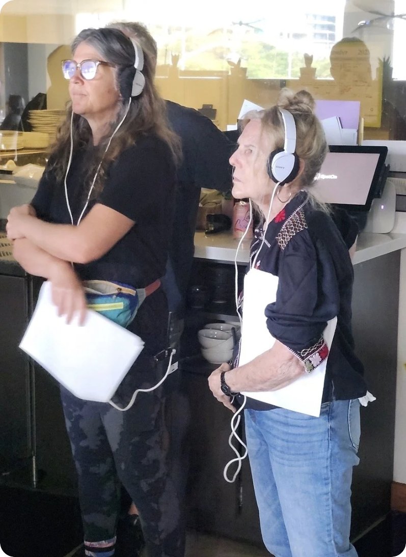 Directing with headphones at the monitor on the set of Profs