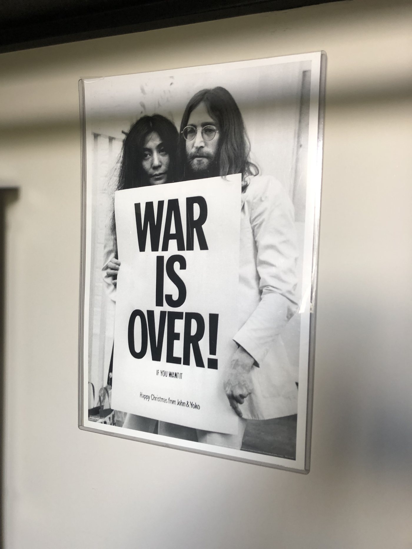 John Lennon and Yoko Ono holding the War Is Over! poster